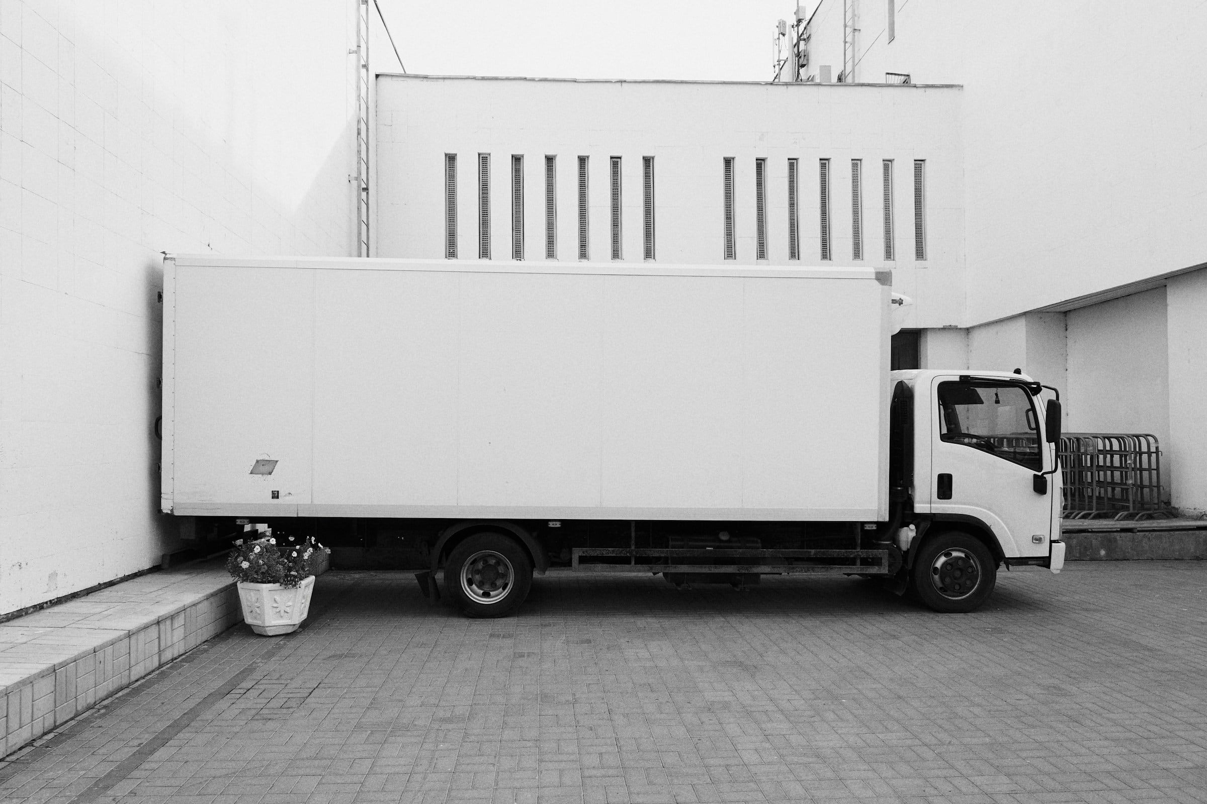 Unbranded white box truck parked outside a building
